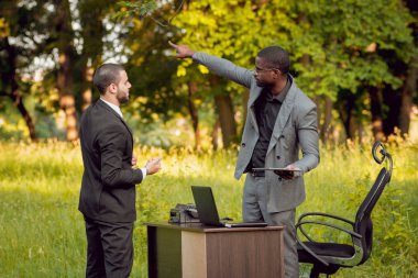 İki genç çok kültürlü iş adamları iş park yerinde. Uzak iş kavramı.