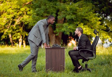 Parkta iş adlı iki genç çok kültürlü businessmans. Uzak iş kavramı.