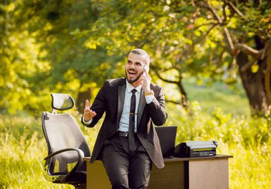 Genç işadamı park içinde işte. Uzak iş kavramı.