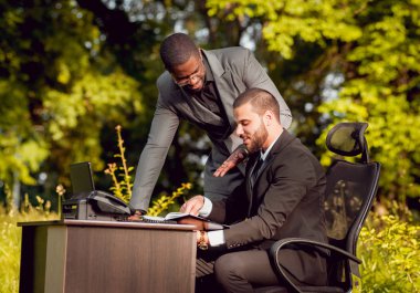 Parkta iş adlı iki genç çok kültürlü businessmans. Uzak iş kavramı.