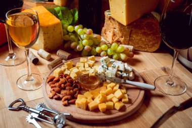 Peynir ve şarap ahşap bir masa üzerinde küpleri.