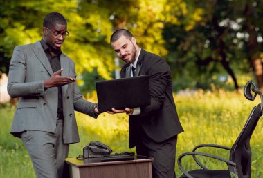 Parkta iş adlı iki genç çok kültürlü businessmans. Uzak iş kavramı.