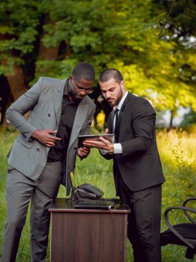 İki genç çok kültürlü iş adamları iş park yerinde. Uzak iş kavramı.