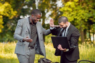 İki genç çok kültürlü iş adamları iş park yerinde. Uzak iş kavramı.