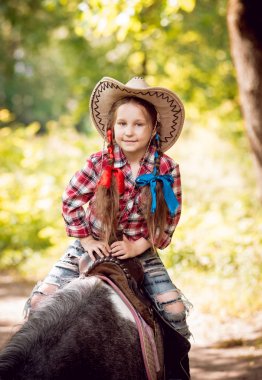 Park midilli sürme kovboy şapkalı örgü ile küçük kız