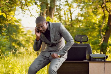 Park içinde İşte genç Afro-Amerikalı iş adamı. Uzak iş kavramı.