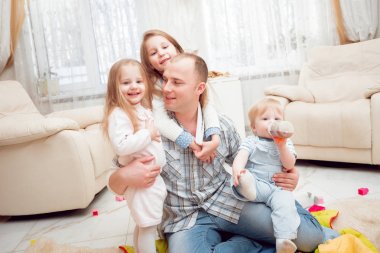 Baba evde çocuklarıyla oynuyor.