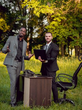Parkta iş adlı iki genç çok kültürlü businessmans. Uzak iş kavramı.