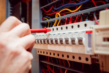 Elektrik donatımı. Elinde Tester.