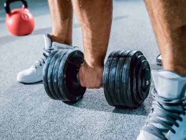 Low angle of hand with dumbbell on floor