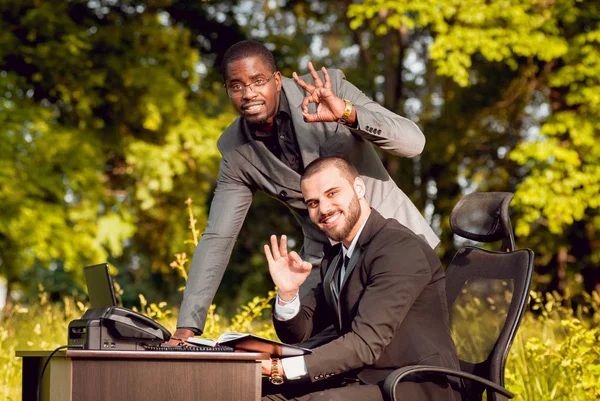 İki genç çok kültürlü iş adamları iş park yerinde. Uzak iş kavramı.