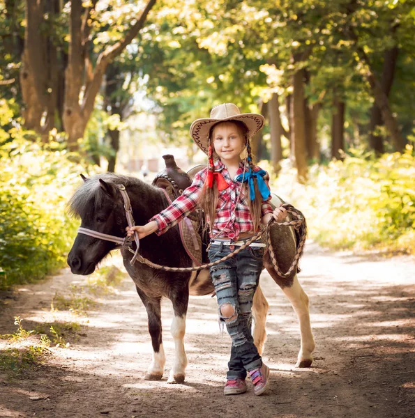 Park midilli sürme kovboy şapkalı örgü ile küçük kız