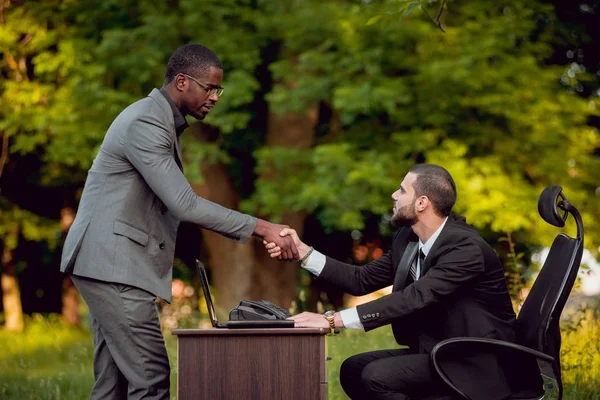 İki genç çok kültürlü iş adamları iş park yerinde. Uzak iş kavramı.