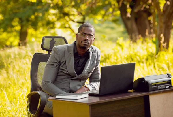 Park içinde İşte genç Afro-Amerikalı iş adamı. Uzak iş kavramı.