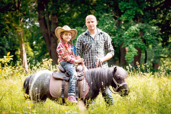 Kleines Mädchen Mit Cowboyhut Beim Ponyreiten Mit Ihrem Vater Park — Stockfoto