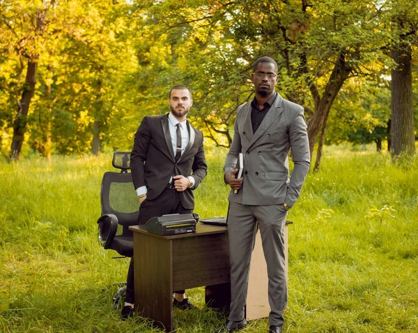 İki genç çok kültürlü iş adamları iş park yerinde. Uzak iş kavramı.