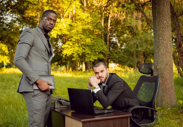 İki genç çok kültürlü iş adamları iş park yerinde. Uzak iş kavramı.