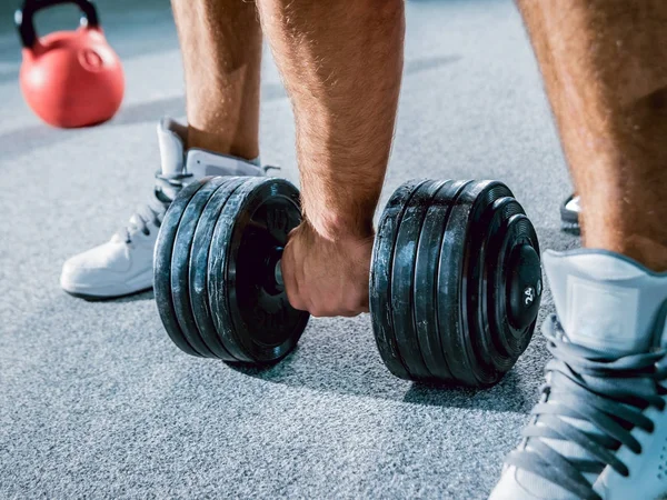 Low angle of hand with dumbbell on floor