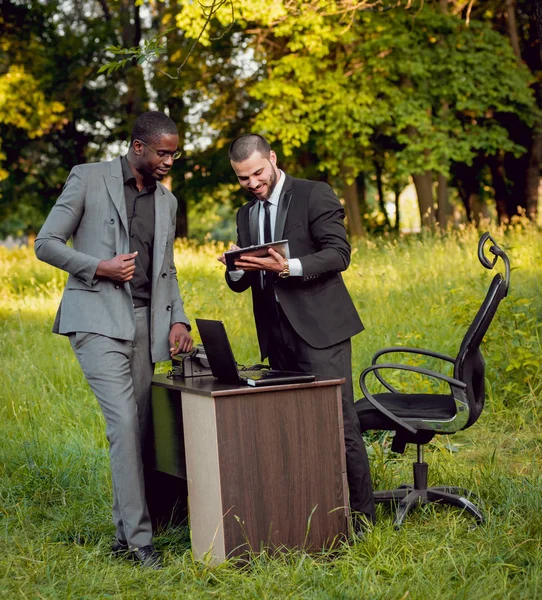 İki genç çok kültürlü iş adamları iş park yerinde. Uzak iş kavramı.
