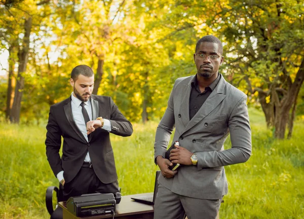 İki genç çok kültürlü iş adamları iş park yerinde. Uzak iş kavramı.