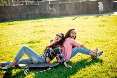 Genç esmer kız açık havada kaykay ile poz