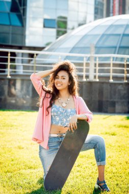 Genç karışık yarış kız açık havada kaykay ile poz