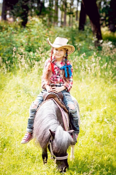 Dziewczynka Plecionki Kowbojski Kapelusz Jazda Pony Park — Zdjęcie stockowe