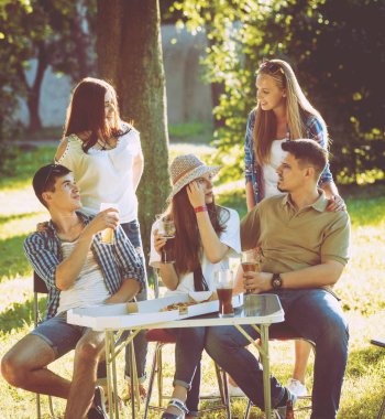 Parkta piknik neşeli arkadaşlar. Gülümseyen ve söz.