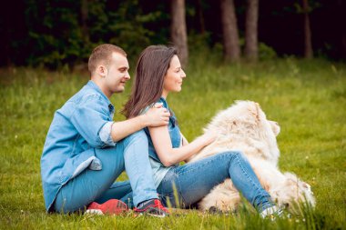 Parkta yürüyüş ve iyi vakit geçiriyorlardı onların köpek uyumak ile genç Çift