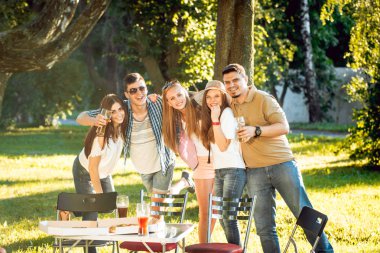 Parkta piknik neşeli arkadaşlar. Gülümseyen ve söz.