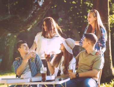 Parkta piknik neşeli arkadaşlar. Gülümseyen ve söz.