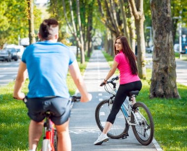 Genç çift yeşil Bisiklet lane güneşli bir günde Bisiklete binme