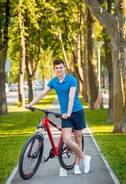 Mutlu genç beyaz adam Yeşil Bisiklet şeritli üzerinde Bisiklete binme