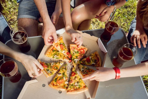 Pizza yemek Park piknik üzerinde neşeli arkadaşlar.