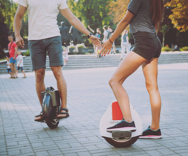 Молодая кавказская пара катается на сегвеях в парке
.