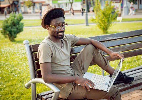 Giovane Africano Cappello Occhiali Con Computer Portatile Nel Parco Verde — Foto Stock