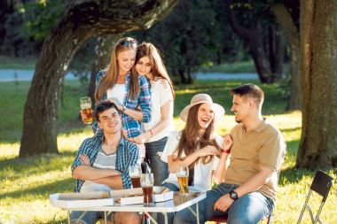 Parkta piknik neşeli arkadaşlar. Gülümseyen ve söz.