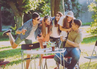 Parkta piknik neşeli arkadaşlar. Gülümseyen ve söz.