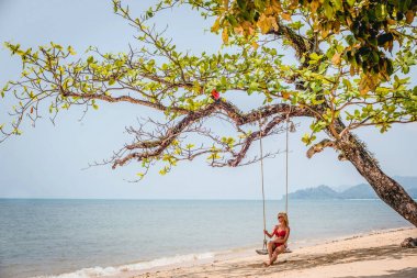Güzel bir kızla sahilde salıncak manzarası