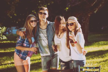 Neşeli arkadaşları Park piknik üzerinde bira içmek. 