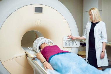 Bayan Beyaz doktor ve femele Orta Doğu hasta hastane MRI odasında.