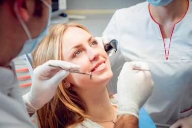 Genç kadın diş ofiste gülümsedi. Tıbbi donatımı