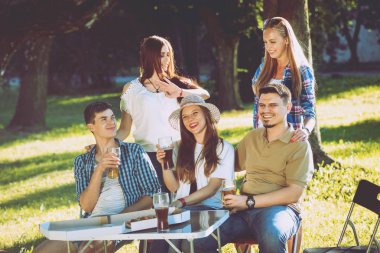 Parkta piknik neşeli arkadaşlar. Gülümseyen ve söz.