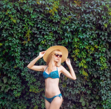 Genç kız mavi mayo yeşil çimenlerin üzerinde rahatlatıcı.