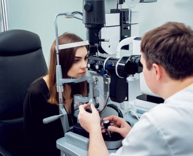 Genç kadın görüşünü göz doktoru ile kontrol. Tıbbi donatımı.