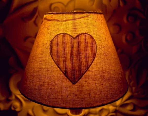 Night lamp with a heart in the bedroom. Background