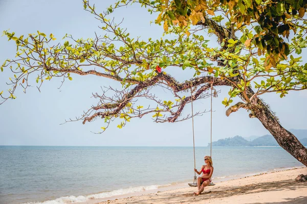 Güzel bir kızla sahilde salıncak manzarası