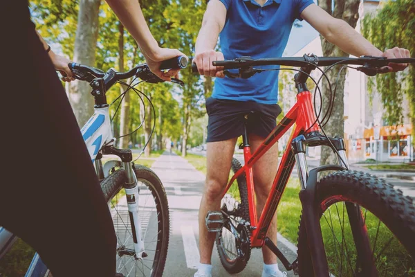 Genç çift yeşil Bisiklet lane güneşli bir günde Bisiklete binme