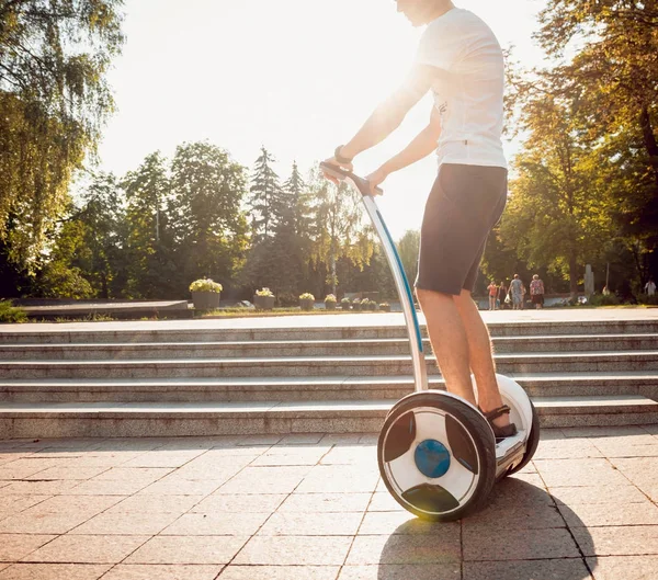 年轻的白种人骑着赛格威在城市公园 — 图库照片