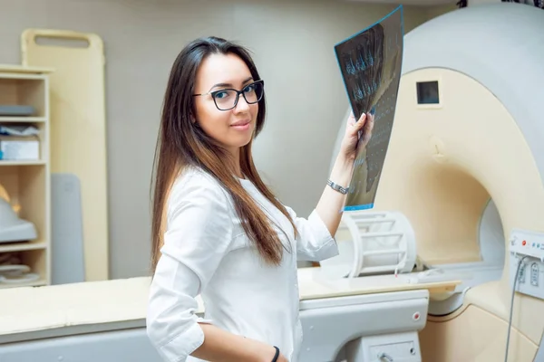 Young female middle eastern doctor in MRI room. Medical equipment.